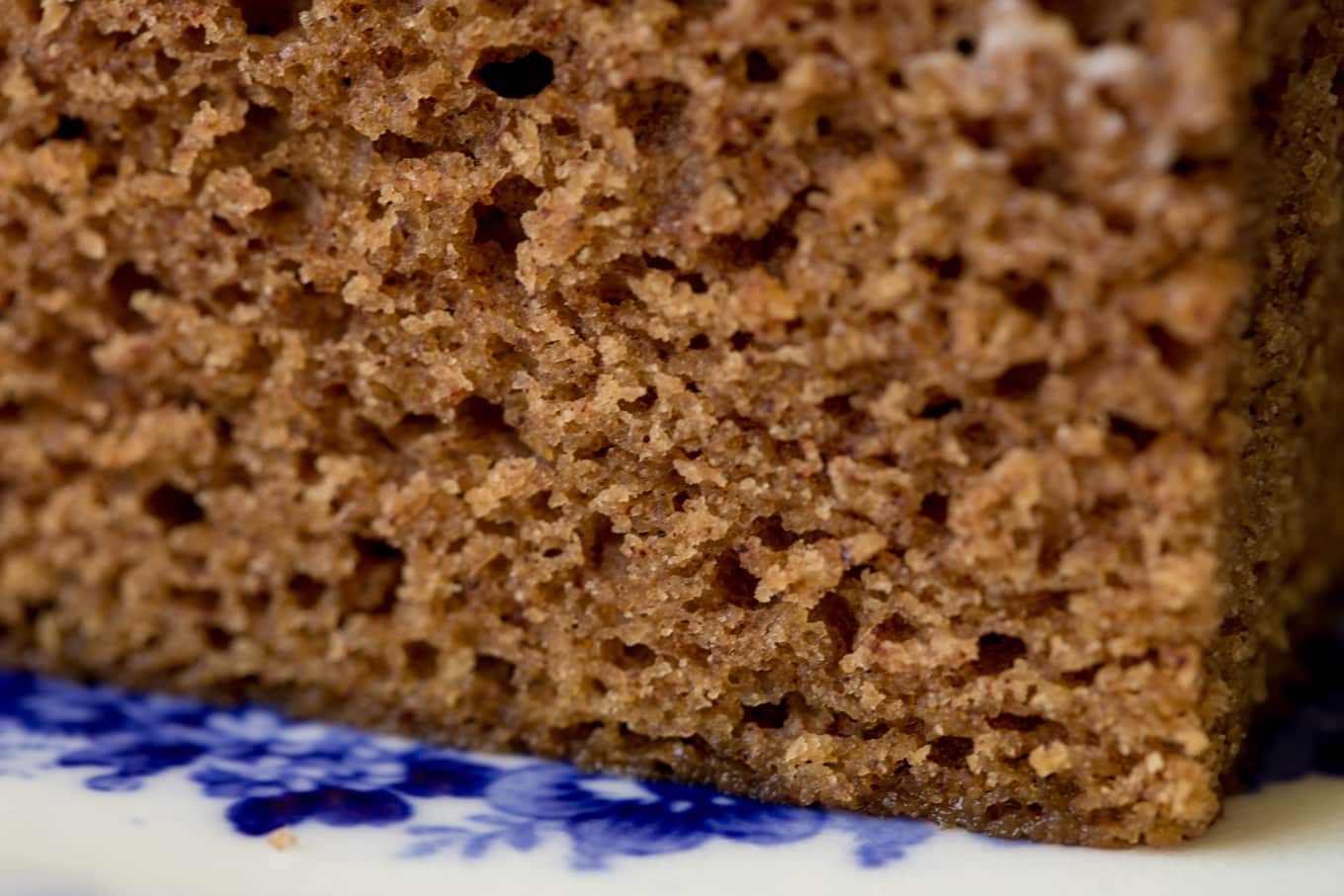 Ultra closeup of the crumb of a piece of Easy Gingerbread Cake with Vanilla Bean Icing.