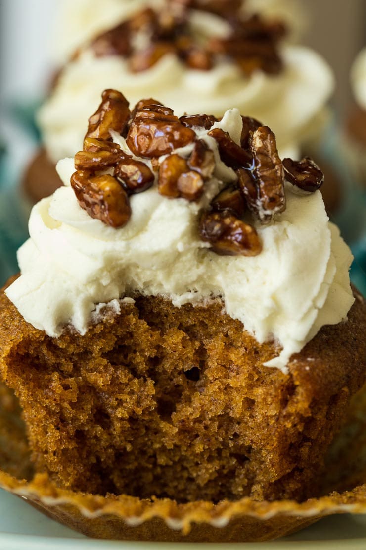 Ultra closeup of the inside of Easy Pumpkin Cupcakes with buttercream frosting and candied pecans on top.