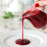 Vertical picture of Easy Raspberry Coulis poured onto a plate