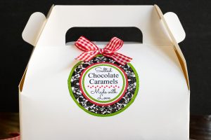 Horizontal photo of a white cardboard box holding the salted caramel chocolates decorated with a green, blue, red, and white label