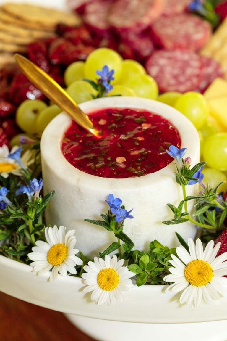 Vertical picture of Strawberry Jalapeno Jam on a charcuterie board with flowers