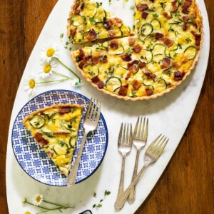 Overhead picture of zucchini summer quiche on a white platter