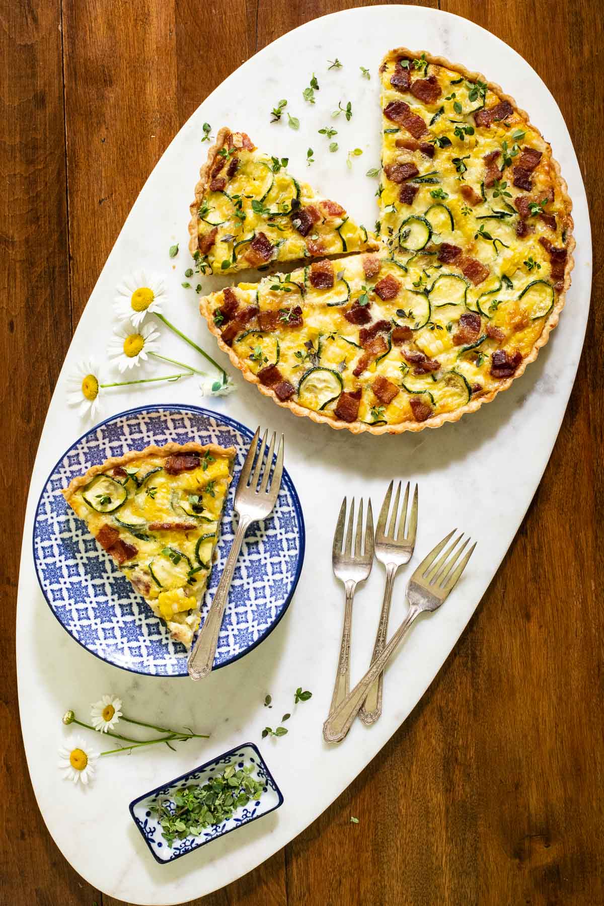 Overhead vertical photo of Easy Zucchini Summer Quiche on a white granite serving platter.