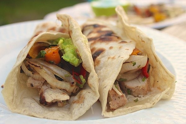 Side photo of two Grilled Chicken Fajitas on a white plate.