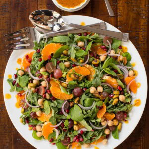 Overhead picture of Fall Salad with Pumpkin Maple Vinaigrette on a white platter with dressing