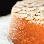 Vertical closeup image of French Almond Cake on a white cake stand