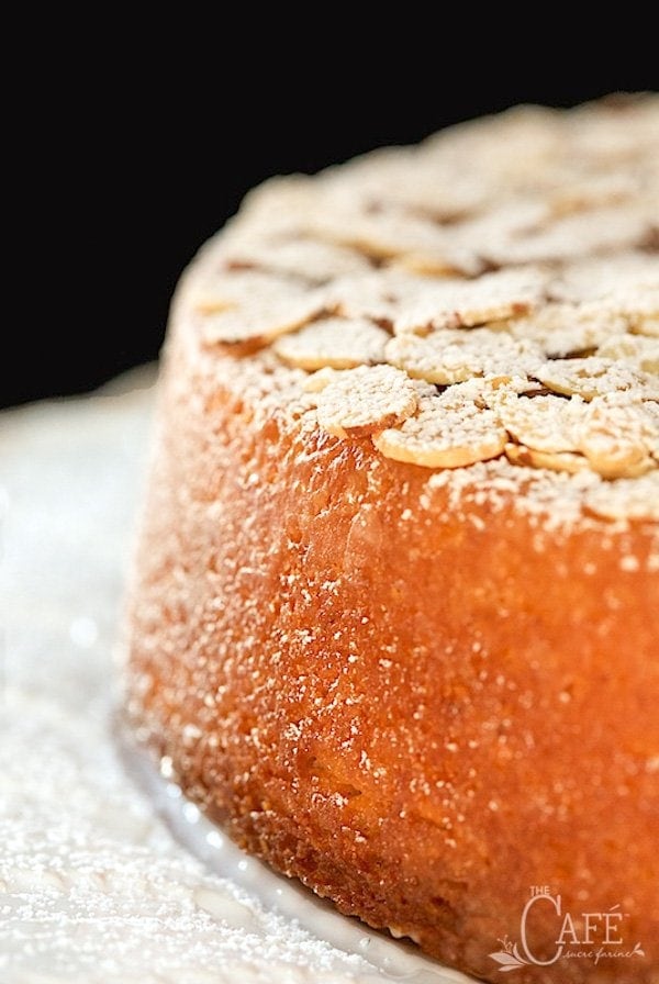 Vertical closeup image of French Almond Cake on a white cake stand 