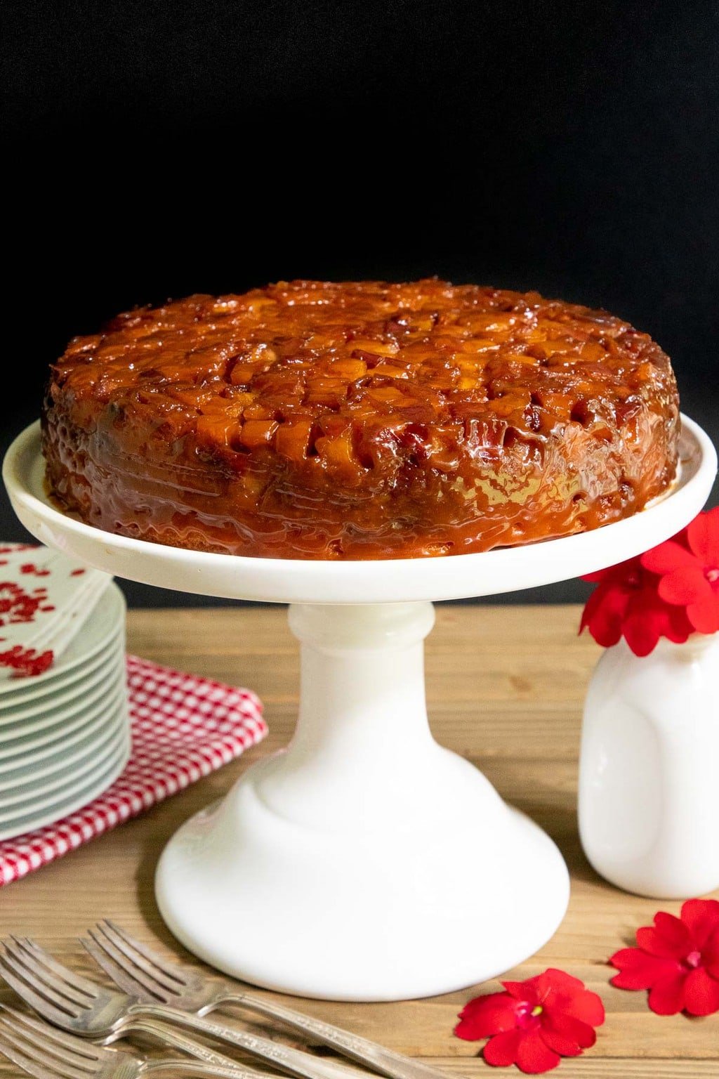 Vertical photo of French Caramel Apple Cake on a white pedestal cake stand.