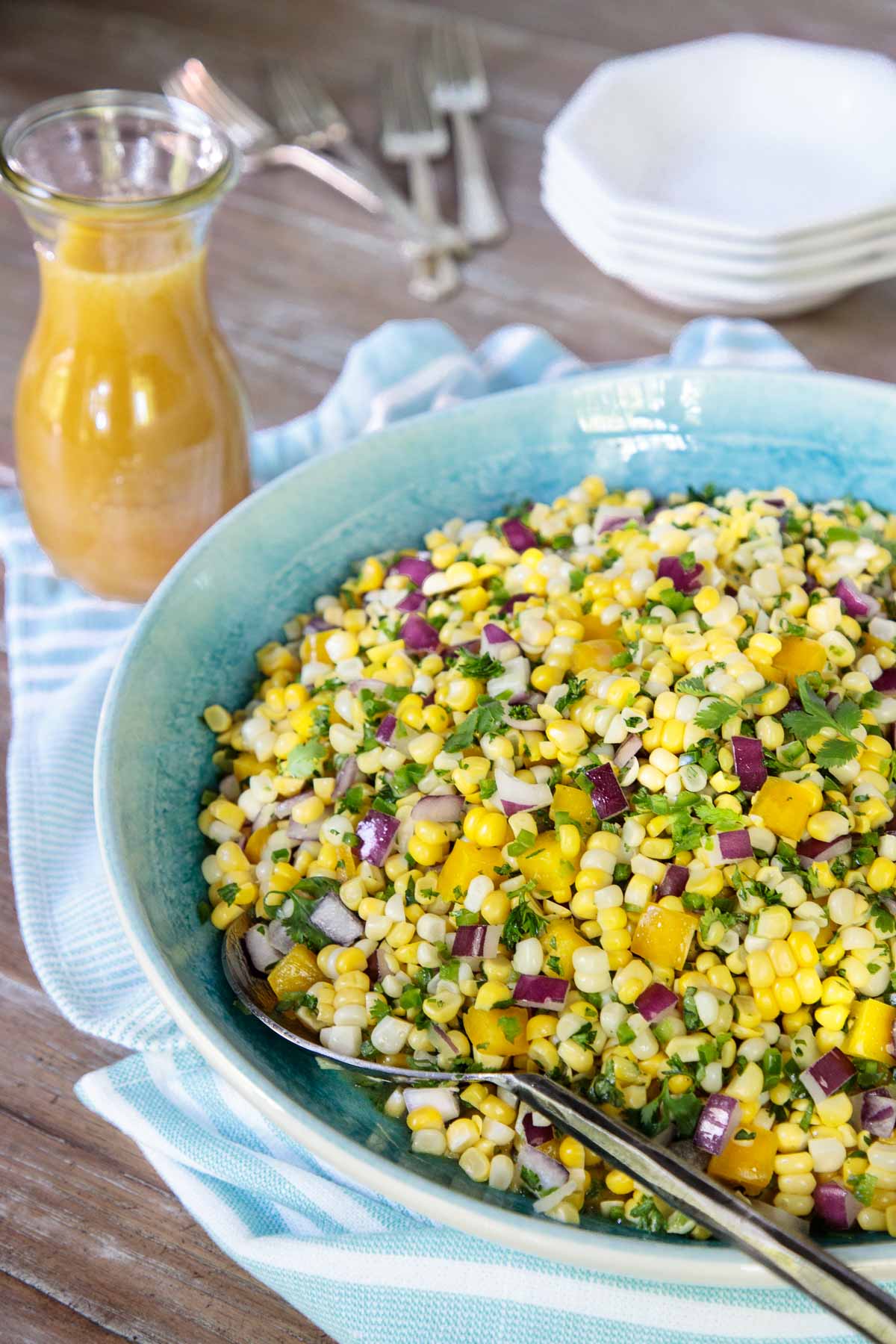 Vertical photo of Fresh Corn Salad in a light turquoise serving bowl.