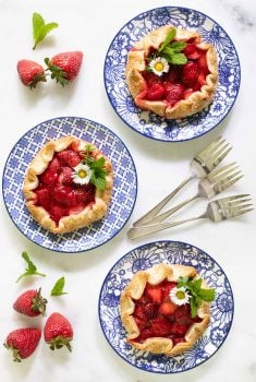 Overhead picture of strawberry galettes on blue and white plates