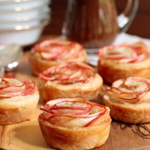 Vertical picture of puff pastry apple roses on a wooden platter
