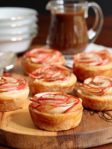 Vertical picture of puff pastry apple roses on a wooden platter