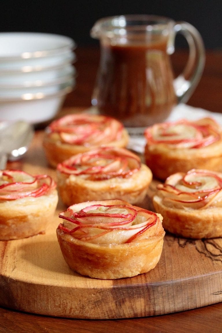 Vertical picture of puff pastry apple roses on a wooden platter