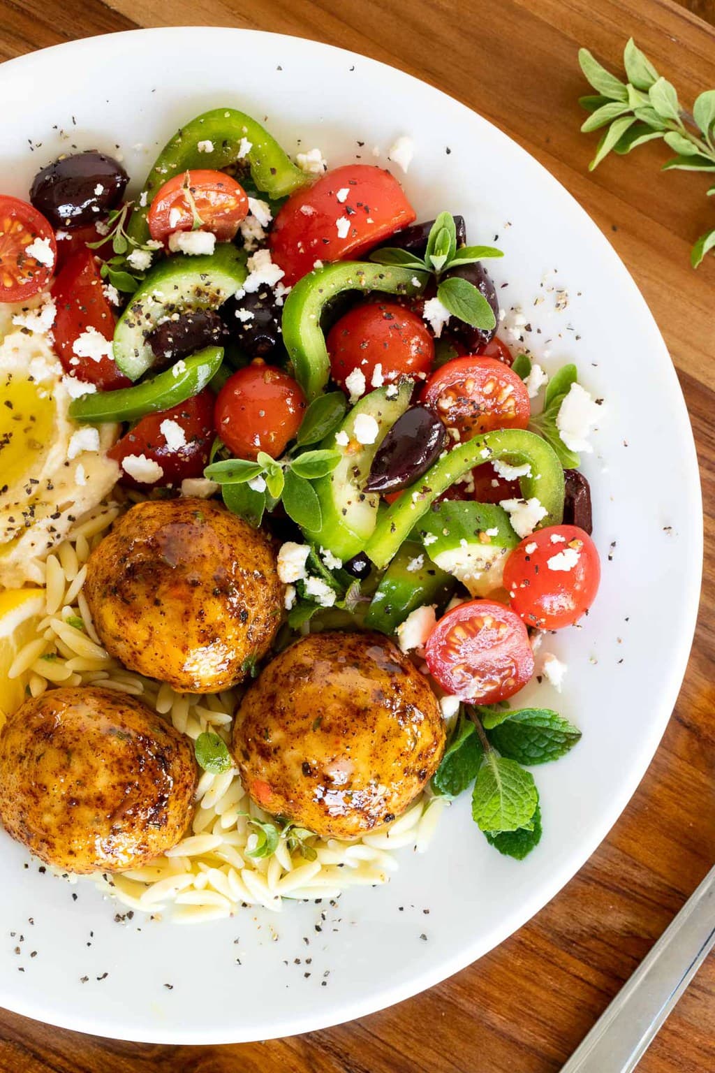 Close up vertical picture of Greek Chicken Meatballs with salad in a white bowl