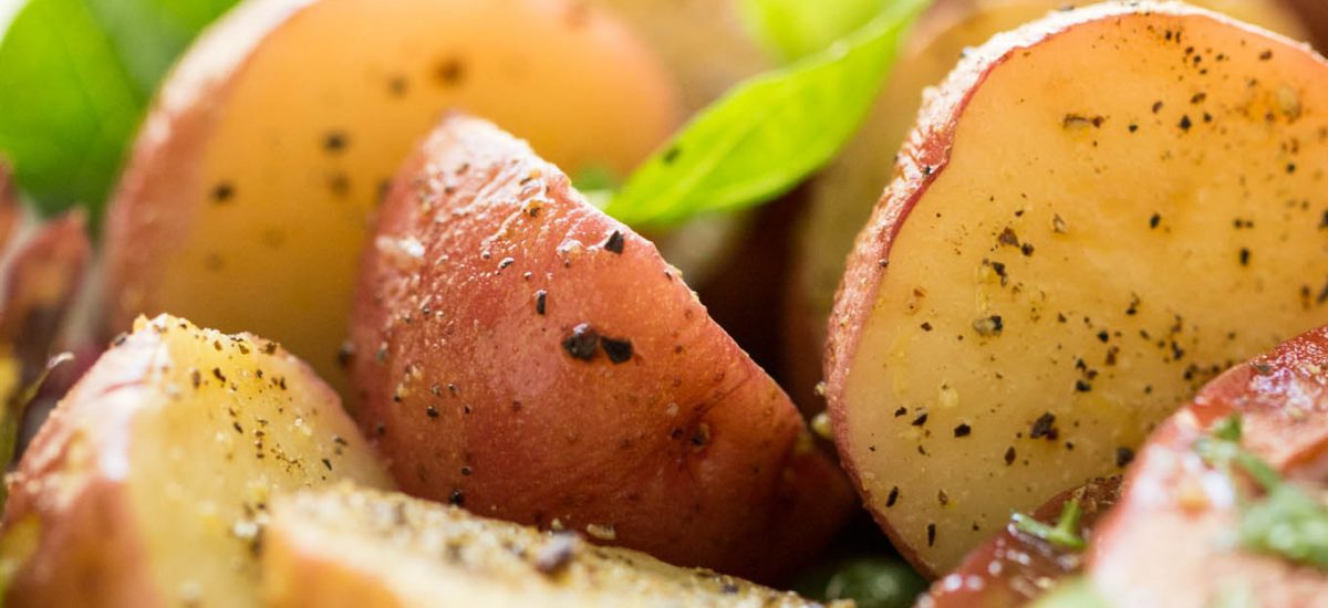 A closeup shot of sliced potatoes, part of a Grilled Chicken Tomato Cucumber Salad.