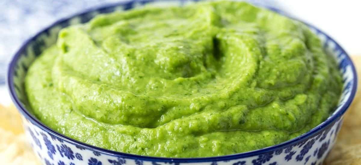 Guasacaca (Venezuelan Guacamole)- thecafesucrefarine.com Closeup photo of a blue and white patterned bowl filled with Guasacaca (Venezuelan Guacamole).