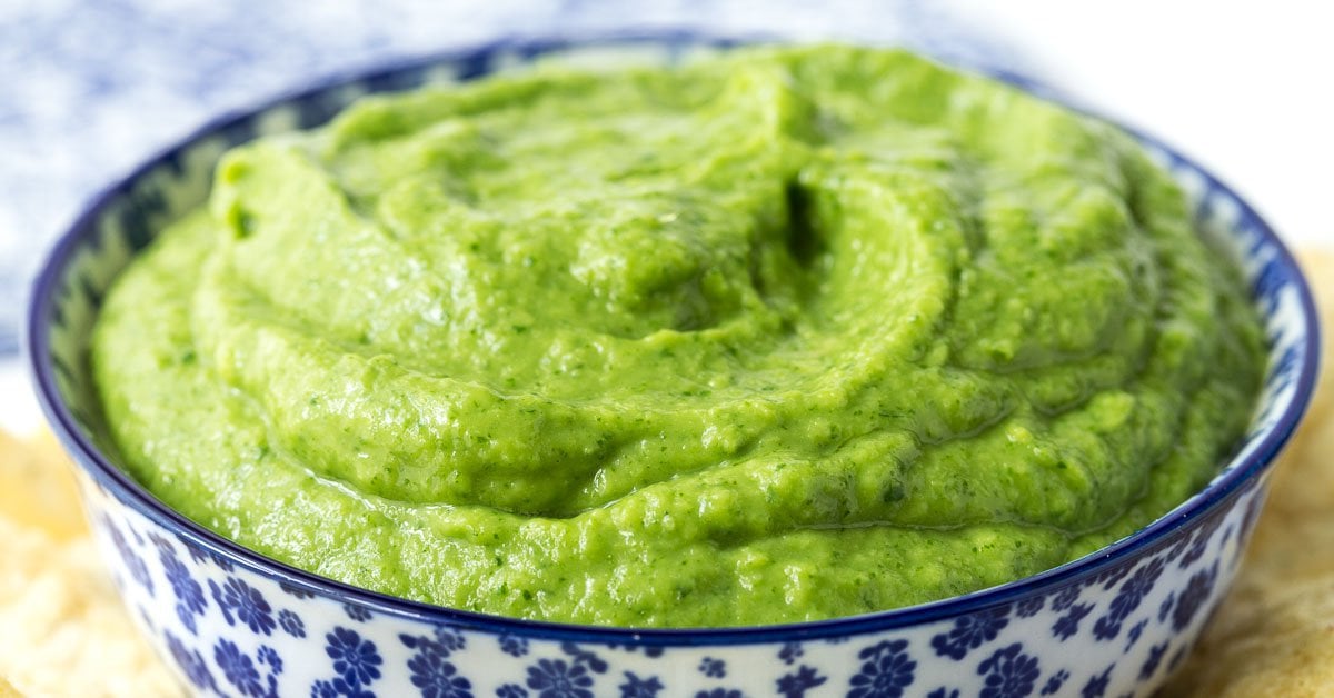 Closeup photo of a blue and white patterned bowl filled with Guasacaca (Venezuelan Guacamole).