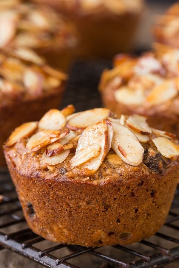 Closeup photo of a Healthy Banana Bran Muffin on a cooling rack with other muffins in the background.