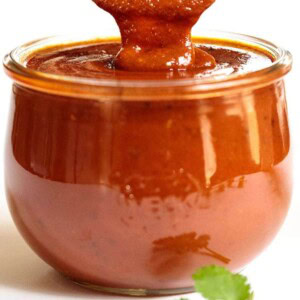 Vertical picture of a glass jar of homemade enchilada sauce