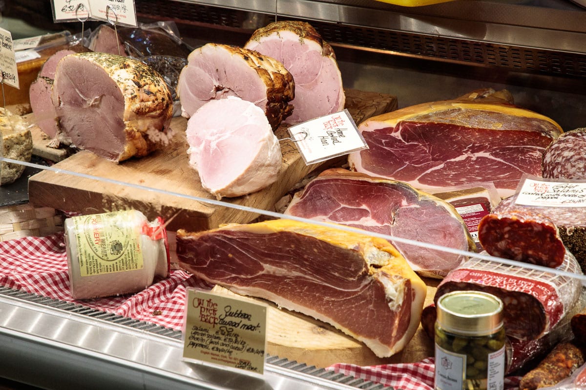 Photo of a myriad of fresh and smoked meats on display at the English Market in Cork, Ireland.