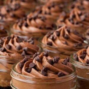 Close up vertical picture of chocolate cheesecake in small mason jars