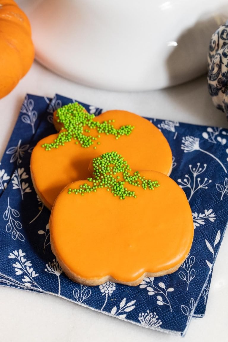Vertical picture of Shortbread Pumpkin cookies on a blue and white napkin