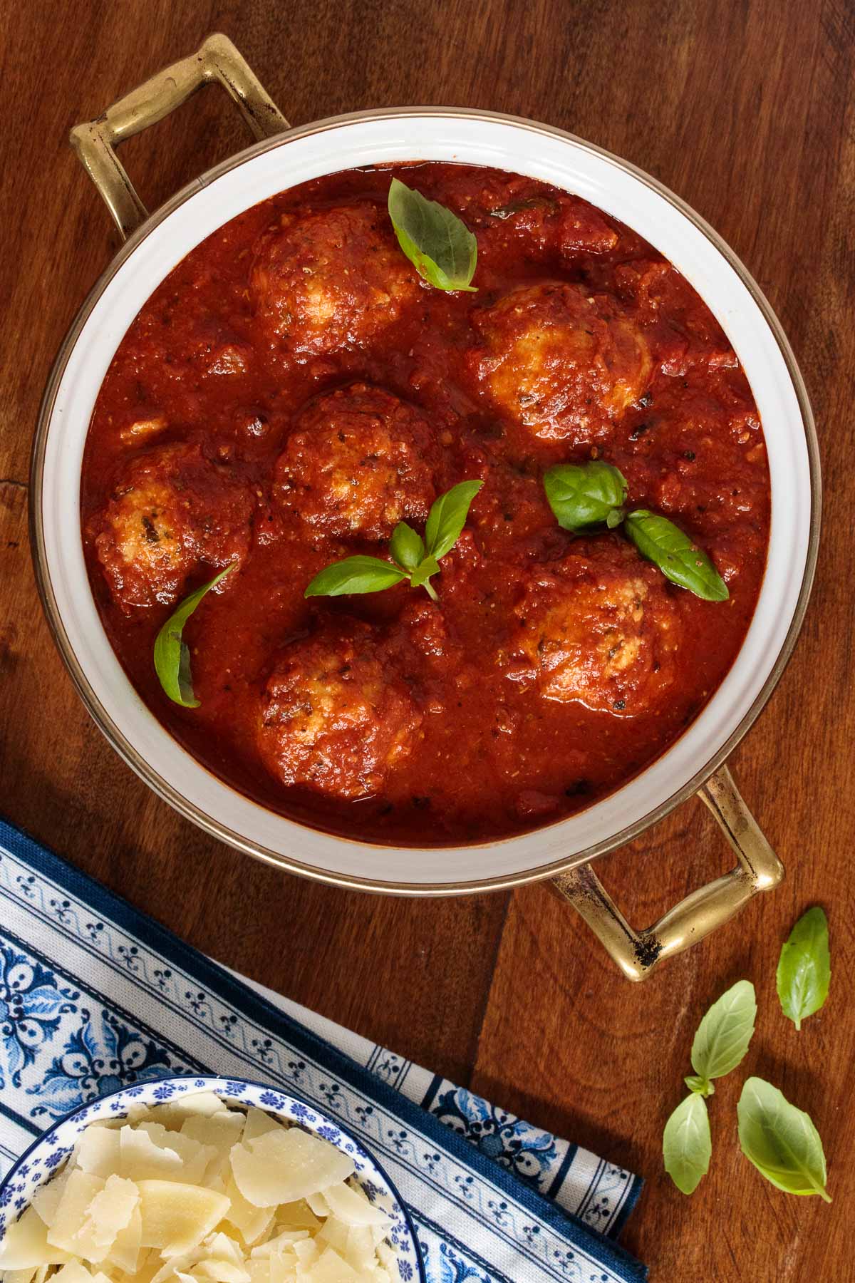 Overhead photo of a pot of Italian Chicken Meatballs and Marinara garnished with fresh basil leaves.