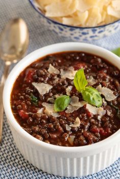 Vertical close up picture of Black Lentil Soup in a small white bowl