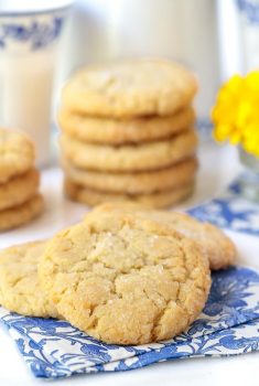 Vertical picture of Lemon Coconut Sugar Cookies stacked on a white and blue napkins