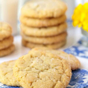 Vertical picture of Lemon Coconut Sugar Cookies stacked on a white and blue napkins