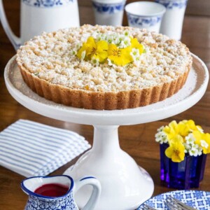 Vertical picture of Lemon Curd Shortbread Tart on a white cake stand