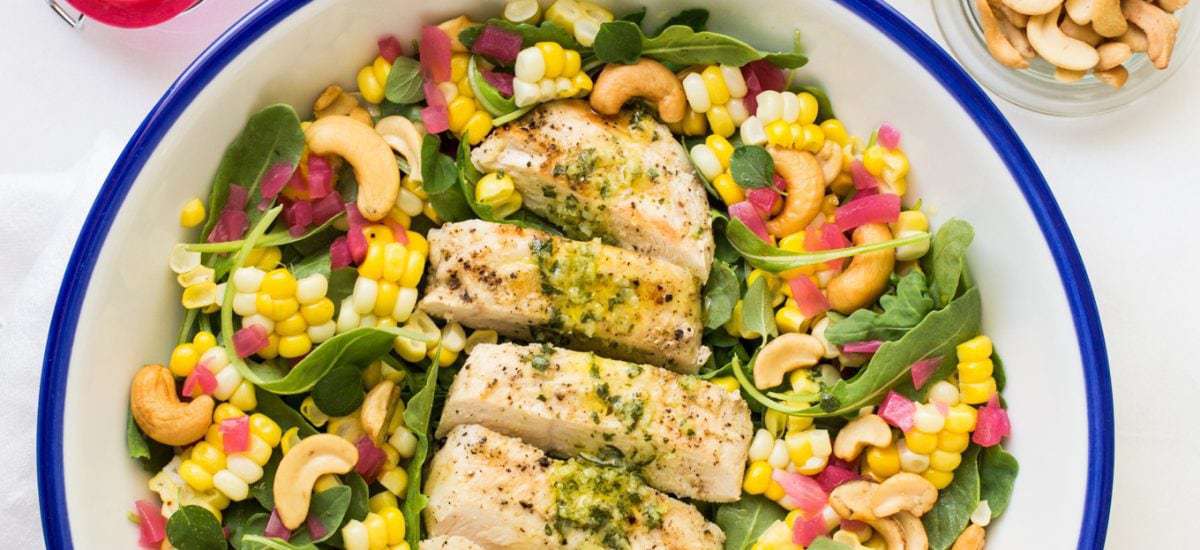 Lemon Oregano Chicken and Corn Salad Overhead picture of Lemon Oregano Chicken and Corn Salad in a white bowl with toppings