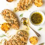 Overhead picture of lemon rosemary grilled chicken breasts garnished with lemons and marinade