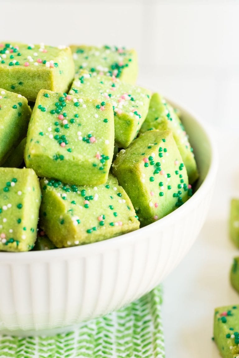 Vertical close up picture of Leprechaun Shortbread Bites in a white bowl