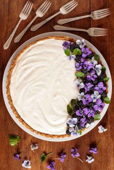 Overhead picture of limoncello lemon tart garnished with purple flowers