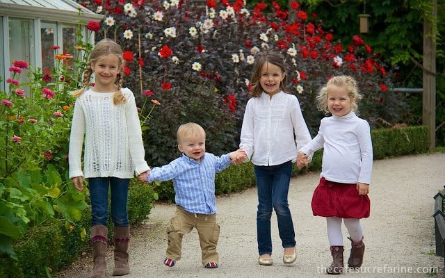 Grandchildren in Bishop's Park Garden in London with colorful flowers in the background.