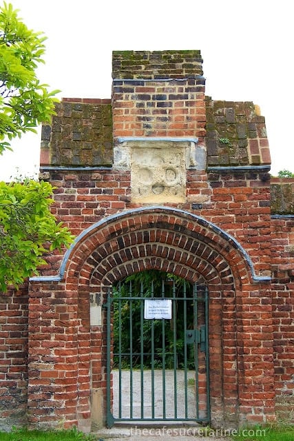 A photo of a stone entrance and iron gate near Bishop's Palace, London, England.