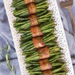 Overhead vertical photo of Bacon Wrapped Green beans on a white lattice serving platter.