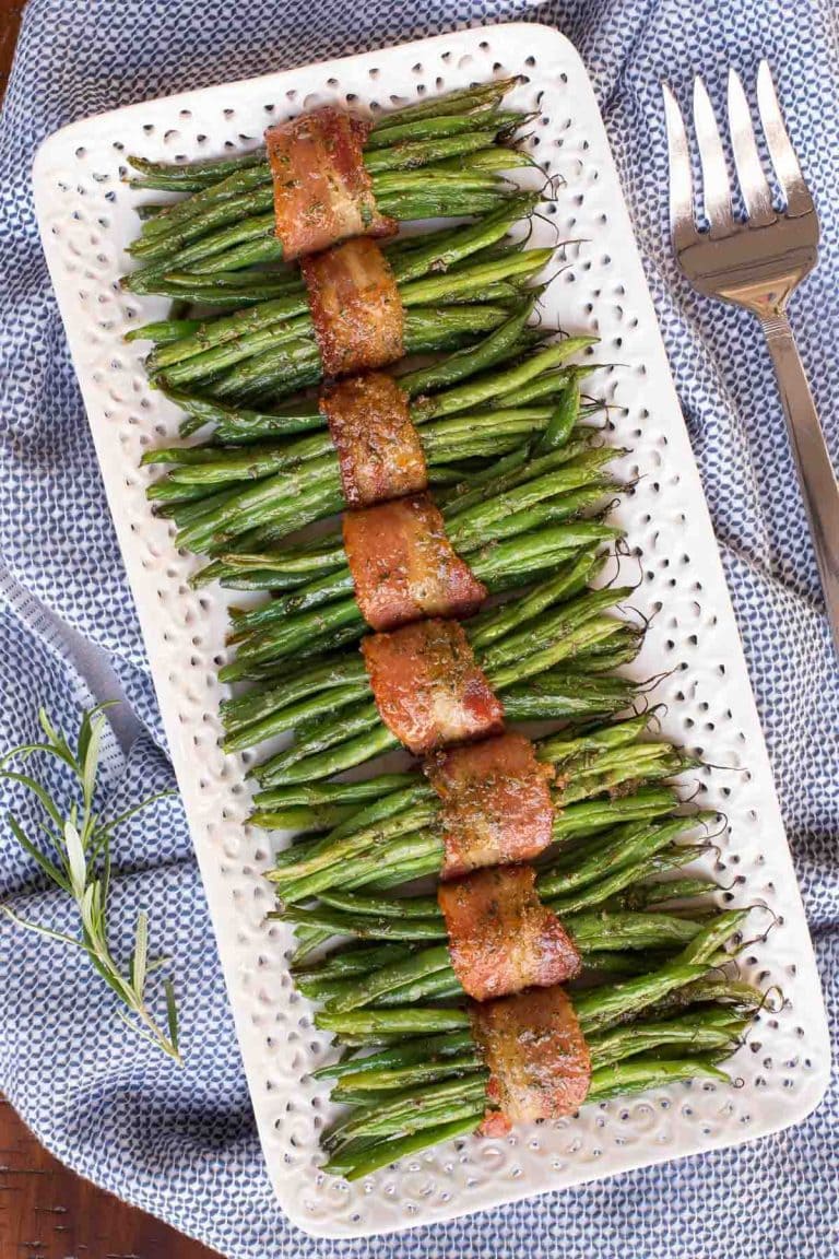 Overhead vertical photo of Bacon Wrapped Green beans on a white lattice serving platter.