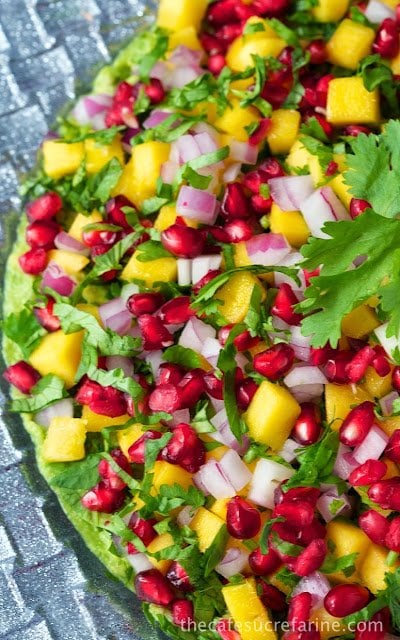This Mango and Pomegranate Guacamole can be served with tortilla or pita chips, on crostini, or as a lovely, unique side dish. It's always sure to dazzle!