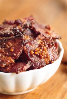 Vertical picture of Maple Mustard Candied Bacon in a white bowl