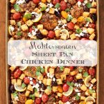 Vertical overhead photo of a person holding a finished pan of Mediterranean Sheet Pan Chicken.