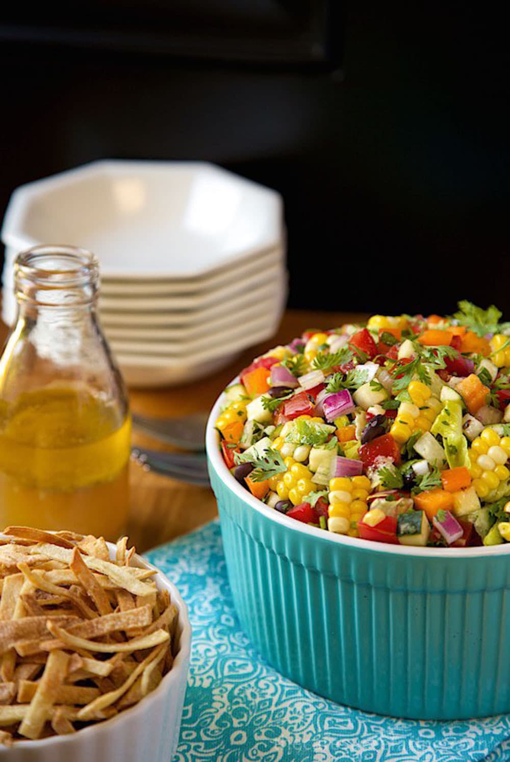 Image of Mexican Chopped Salad with serving bowls and dressing.