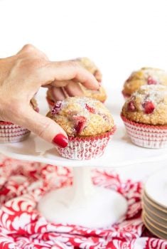 Vertical photo of Fresh Strawberry Buttermilk Muffins on a white pedestal cake stand.