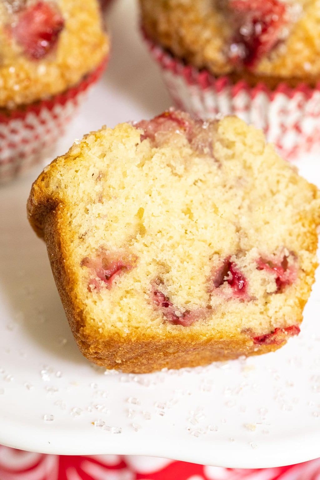 Closeup of the inside crumb of a Fresh Strawberry Buttermilk Muffin on a white cake plate.