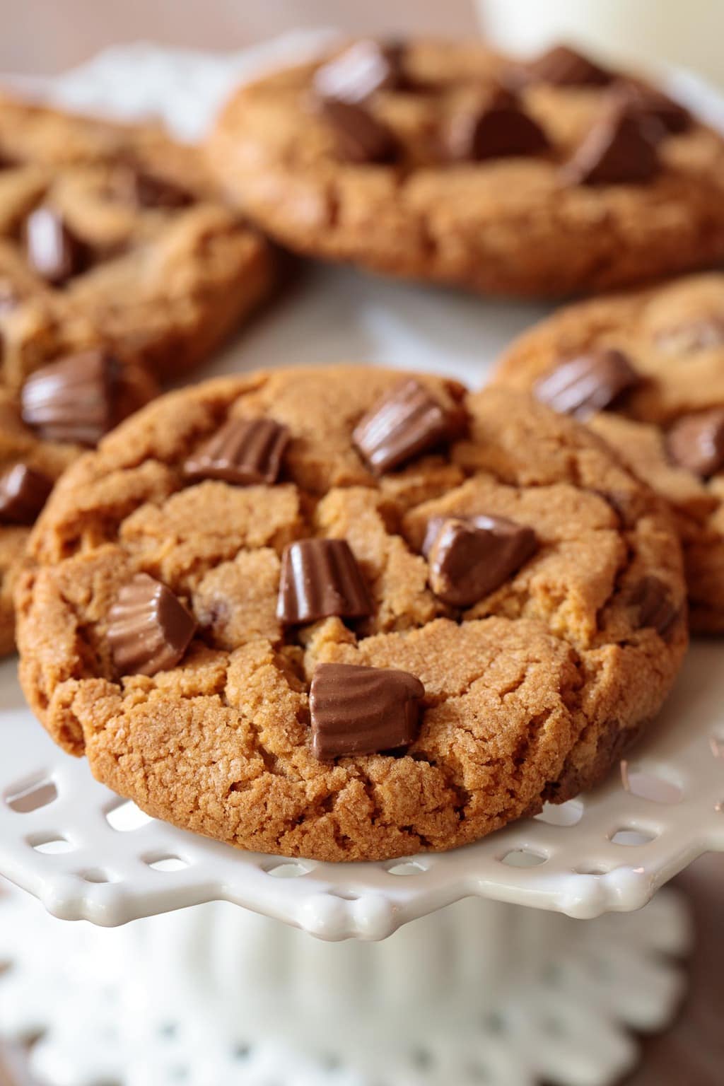 Closeup photo of a white pedestal plate filled with One-Bowl Reese's Peanut Butter Cookies.