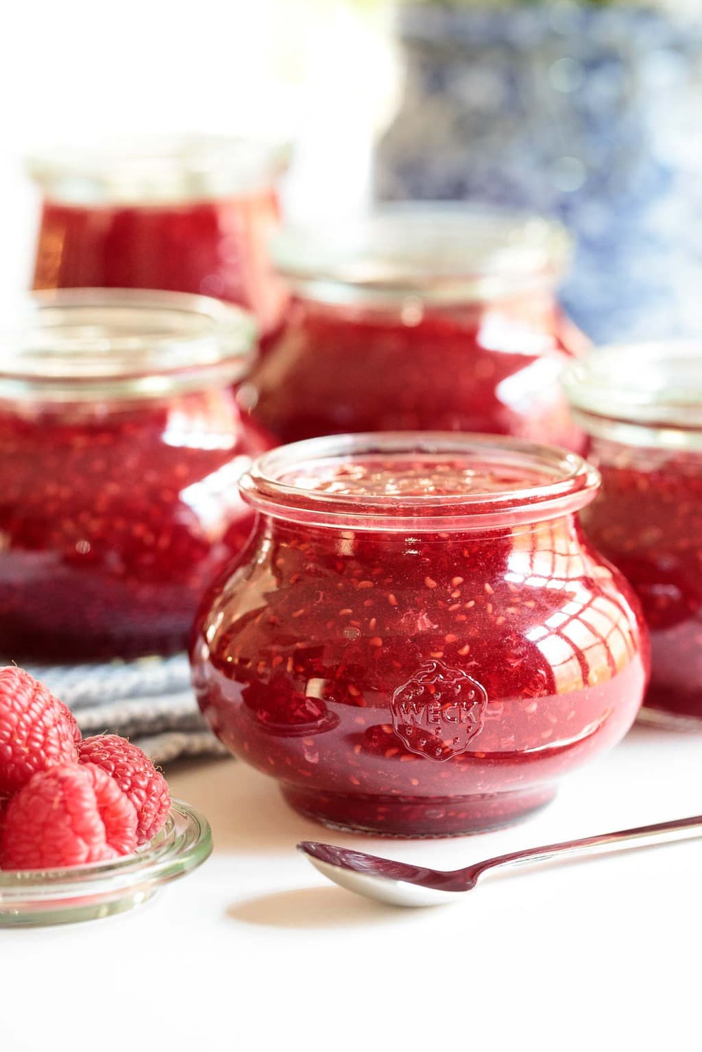 Vertical closeup photo of Easy Raspberry Freezer Jam in glass Weck canning jars.
