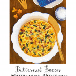 Vertical overhead photo of a Butternut Bacon Spinach Quiche on a white scalloped serving plate.