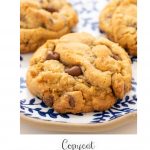 Vertical extreme closeup photo of a batch of Crumbl Chocolate Chip Cookies on a blue and white platter.