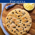 Vertical photo of a loaf of Ridiculously Easy Cinnamon Raisin Focaccia with a graphic title in a blue band at the top of the photo
